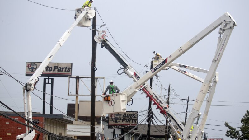 Utility crews work to restore electricity in Houston on Thursday. Prolonged outages following Hurricane Beryl has some fed-up and frustrated residents taking out their anger on repair workers who are trying to restore power.