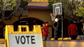 Kids play outside a polling precinct, Tuesday, March 19, 2024, in Guadalupe, Ariz. 