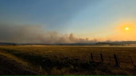 A field with with smoke bellowing out of the center.