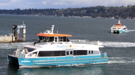 Two Kitsap County Fast Ferry vessels traverse the waters near the ferry terminal in Bremerton
