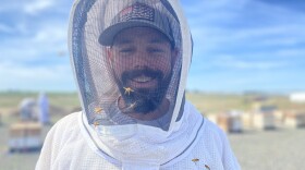 Brandon Hopkins, a bee researcher with Washington State University, smiles from inside his bee suit’s protection at the university’s honey bee research facility near Othello, Washington.