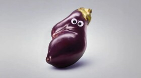 An eggplant with googly eyes on it. 