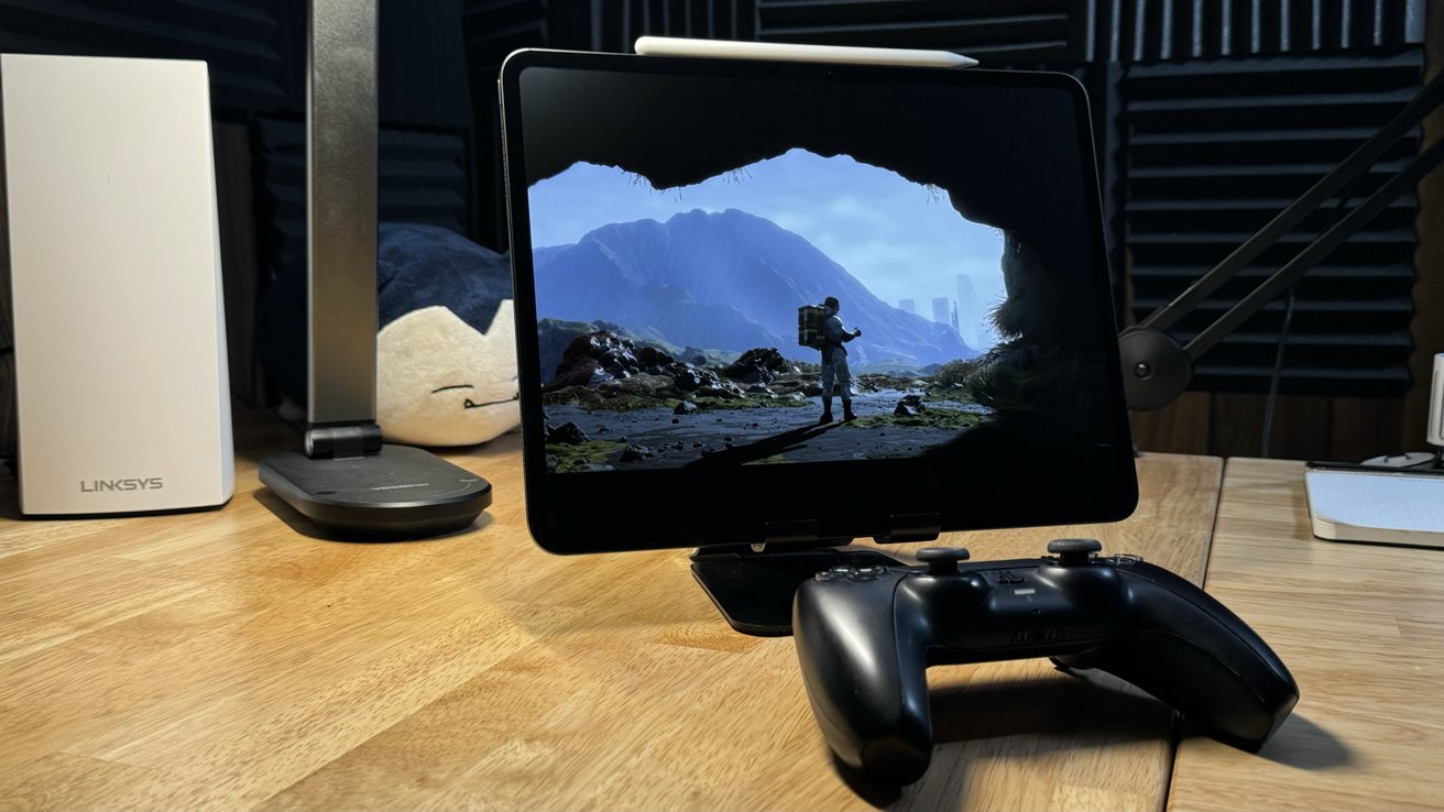 iPad Pro in a stand on a desk with a controller in front. A scene from 'Death Stranding' is shown.