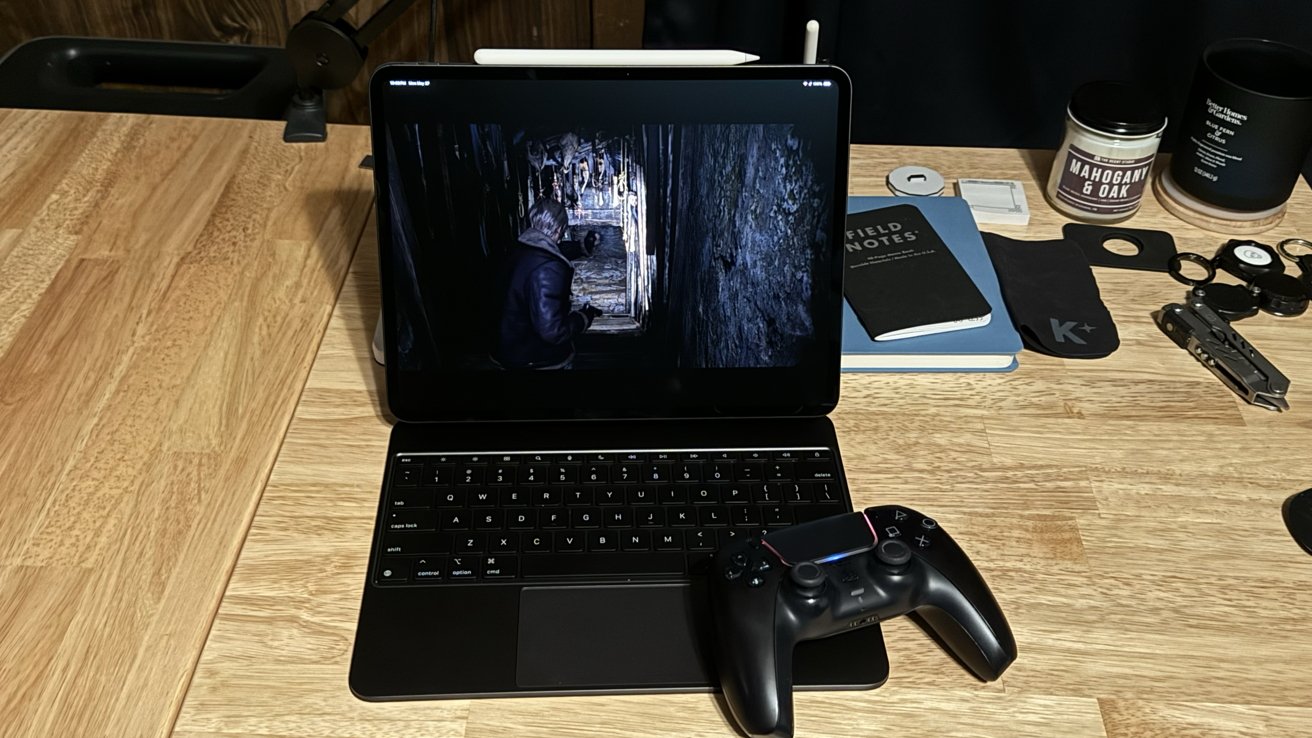 'Resident Evil 4' running on an iPad Pro sitting on a desk in the Magic Keyboard. A game controller is next to the keyboard.