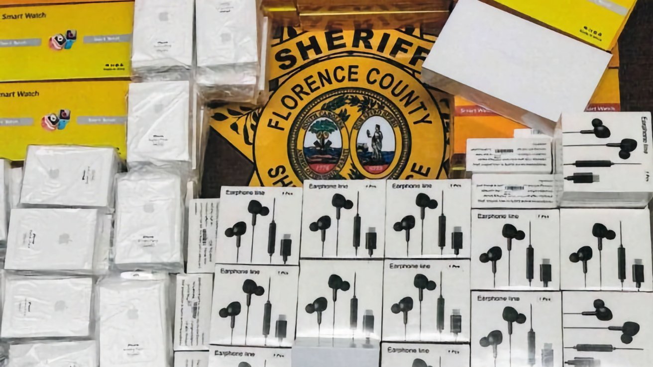 Seized counterfeit electronics including earphones and smartwatches displayed on a table with a Florence County Sheriff badge in the background.