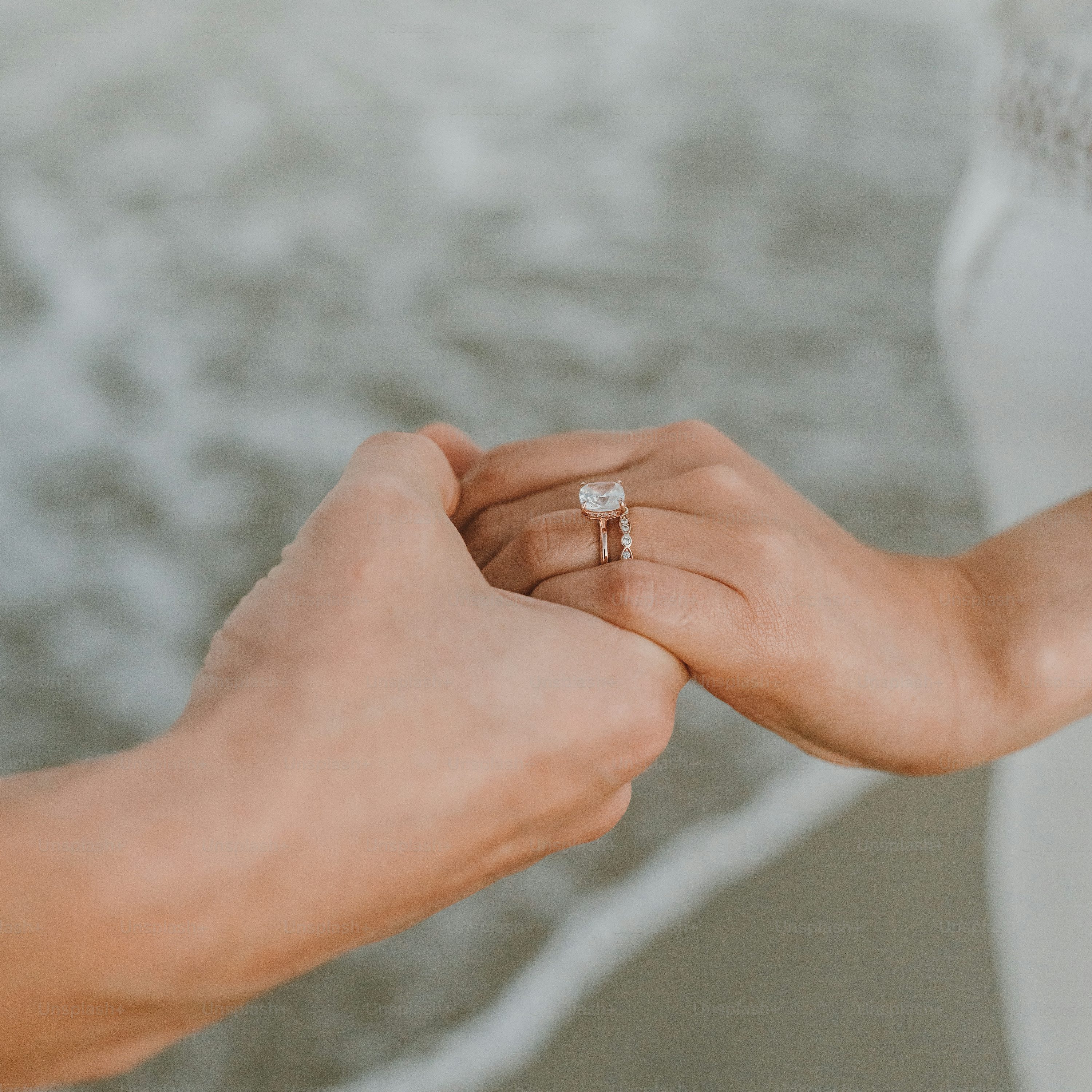 결혼 반지를 들고 있는 한 쌍의 손