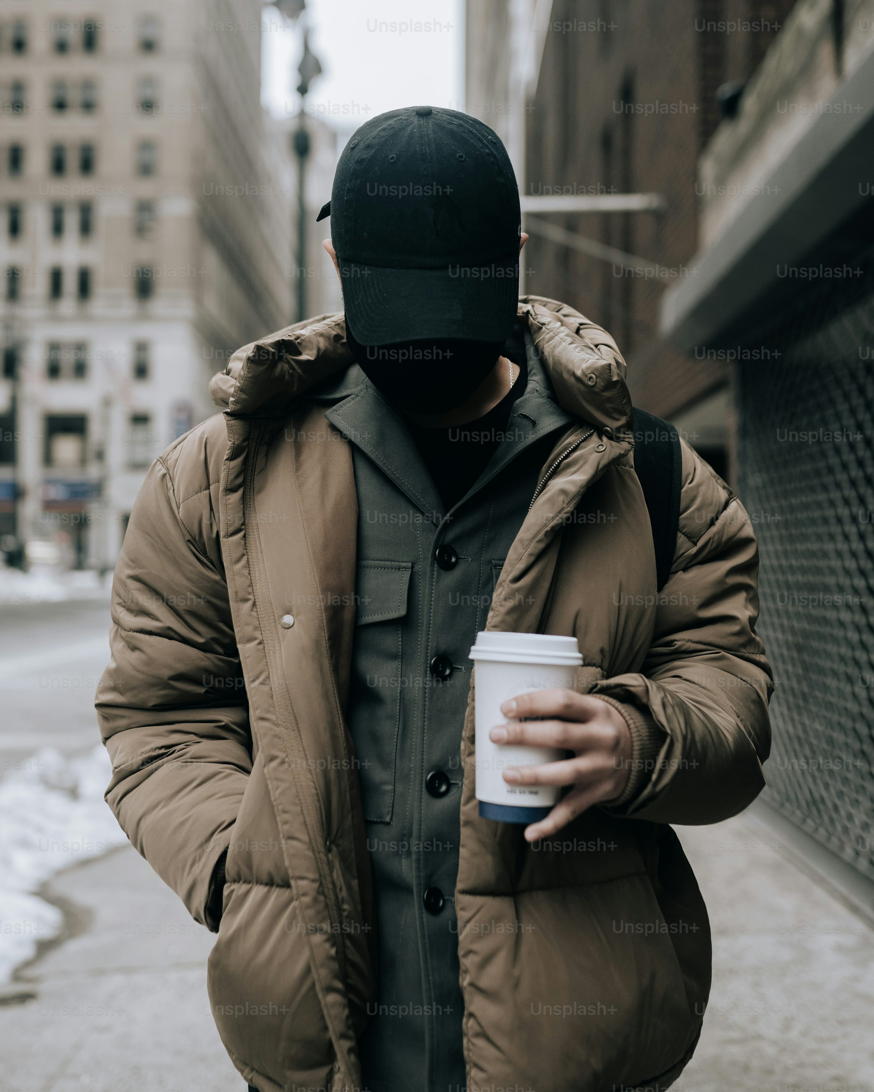 Un hombre caminando por una calle sosteniendo una taza de café