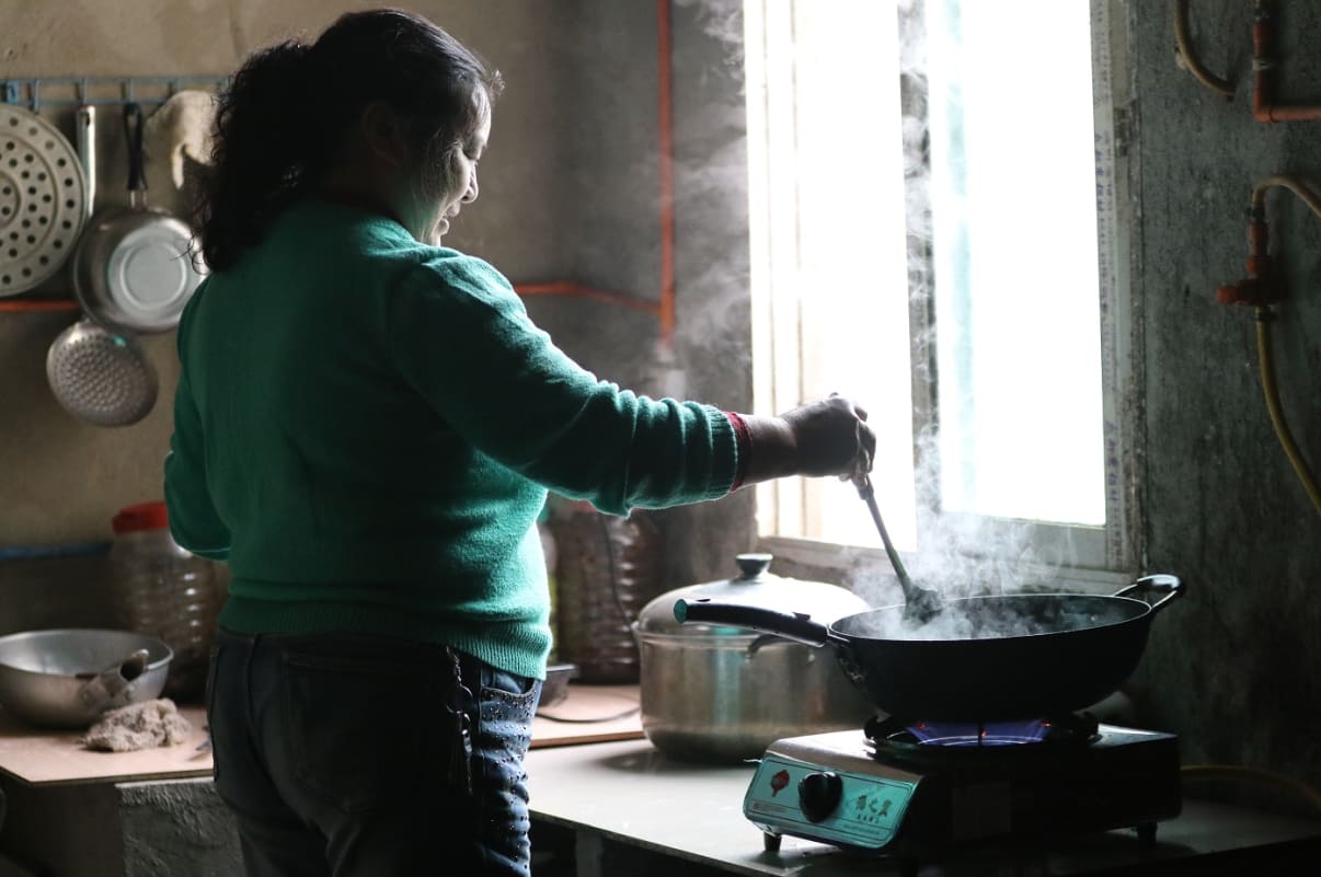 person cooking at home using biogas