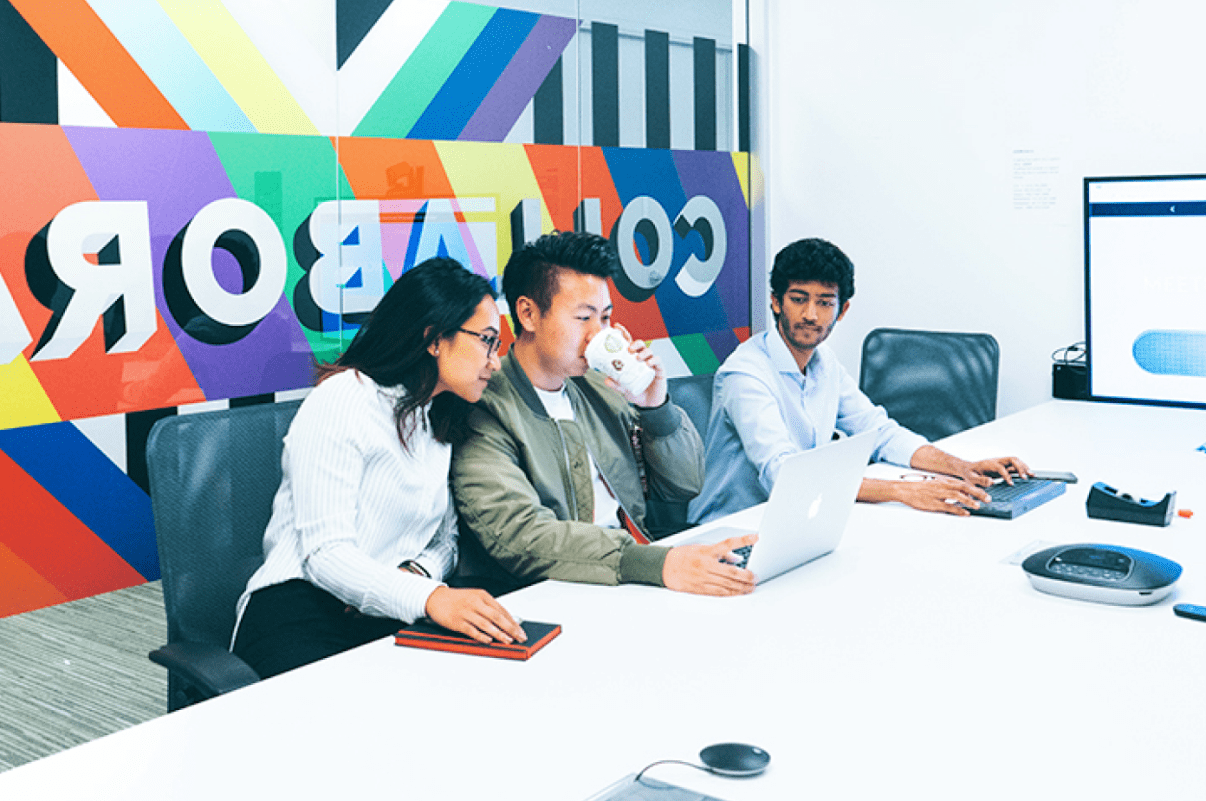 3 people in a meeting room using renewable electricity