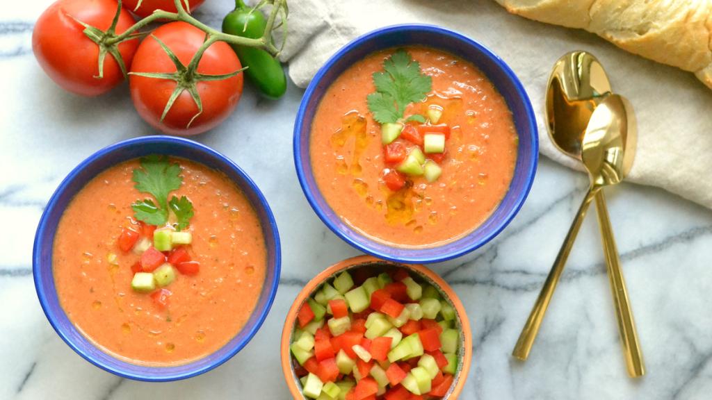 Dos platos de gazpacho, con sus trozos de pimiento y su pepino.