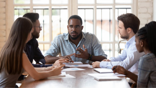 Marketing-team-sitting-around-a-table-going-over-charts