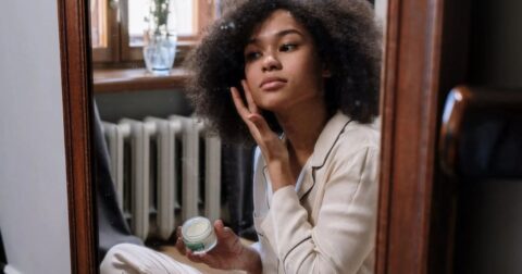 A woman applying skincare product