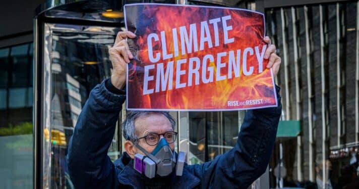 A man holds a sign that says 