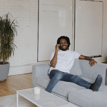 This is a picture of a man on a sofa on the phone