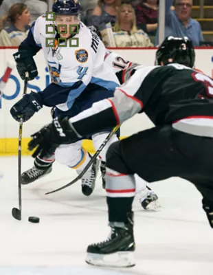 Two hockey players face off for the puck