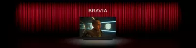 Image of a cinema with red curtains and Sony TV centre stage with screenshot of a person in a sci-fi movie, the word BRAVIA above and Sony soundbar below