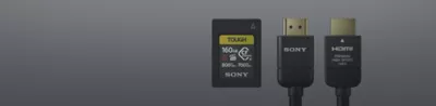 A Sony Tough SD card and two black Sony cables on a grey background