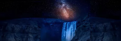 Dramatic image of the night sky above a waterfall