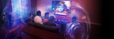 Living room scene with three people sitting on a sofa and wall-mounted TV and soundbar with sound spheres showing 360 Spatial Sound Mapping