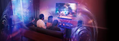 Living room scene with people people sitting on a sofa and wall-mounted TV and soundbar with sound spheres showing 360 Spatial Sound Mapping