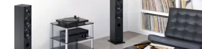 Bluetooth vinyl record player and an amplifier on a glass table in a living room