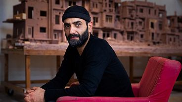 Le sculpteur syrien Khaled Dawwa travaille sur son œuvre "Voici mon cœur !"en argile, représentant une rue en Syrie détruite par les forces du régime syrien