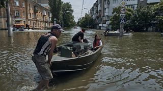 Kisállatokat és embereket evakuáltak egy csónakon az ukrajnai Kherson egyik elárasztott negyedéből 2023. június 8-án, csütörtökön.