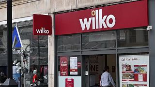 Un ciclista passa davanti a una filiale di Wilko a Londra