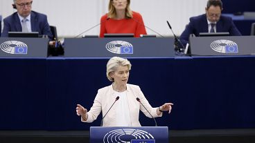 A Presidente da Comissão Europeia, Ursula von der Leyen, dirige-se ao Parlamento Europeu enquanto a sua Presidente, Roberta Metsola, observa, 18 de julho de 2024