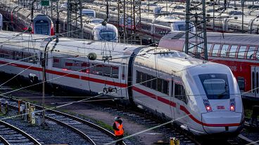 Un empleado de Deutsche Bahn camina junto a los trenes ICE que están estacionados cerca de la estación central de trenes de Frankfurt, Alemania, el lunes 27 de marzo de 2023.