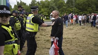 Agentes da polícia enfrentam manifestantes à porta do Holiday Inn Express em Rotherham, Inglaterra, domingo, 4 de agosto de 2024.