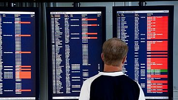 Um passageiro olha para os ecrãs de informação que mostram os voos cancelados no aeroporto de Arlanda, nos arredores de Estocolmo