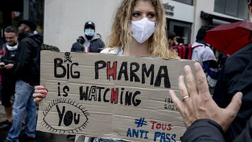 Архив: женщина с плакатом "Big pharma следит за вами" на кции протеста против вакцинных паспортов в Париже, Франция, август 2021 г.