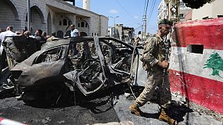 Un soldat de l'armée libanaise passe devant une voiture touchée par une frappe israélienne dans la ville de Sidon, au Liban, mercredi 21 août 2024. (AP Photo/Mohammad Zaata)