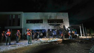 Des militaires et des policiers israéliens travaillent sur un bâtiment scolaire endommagé par des missiles tirés depuis l'Iran à Gadera, en Israël.