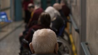 Ancianos esperan en una cola en Roma.