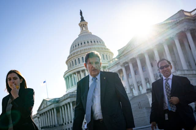 <p>West Virginia Democratic Senator Joe Manchin, centre, leaves the US Capitol following a vote on 27 October, 2021</p>