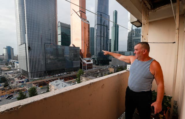 <p>A Moscow resident points at a damaged building in the city’s business district after a drone attack on 23 August </p>