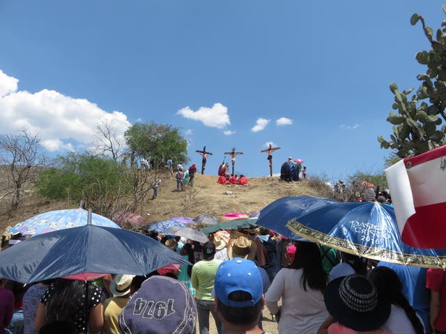 Local news photographers crowd round, trying to get the perfect shot, and a whole sea of umbrellas spring up as people shelter from the heat