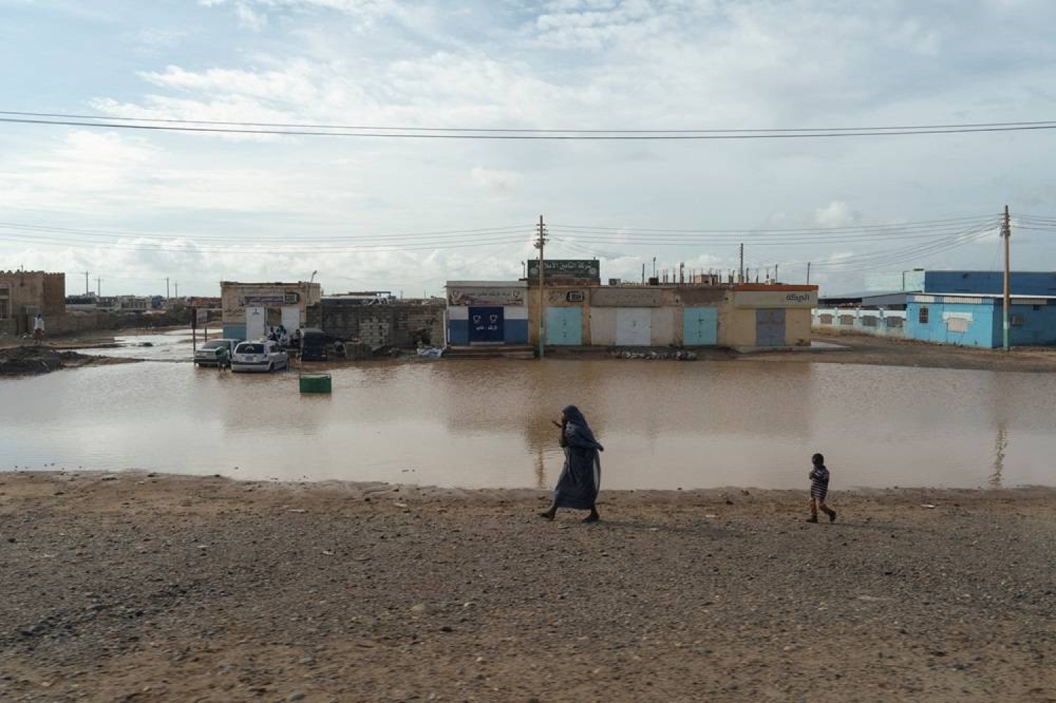  A displaced Sudanese woman walks next to a flooded street, following a heavy rainfall in Kassala, Sudan, July 26, 2024. (Reuters)