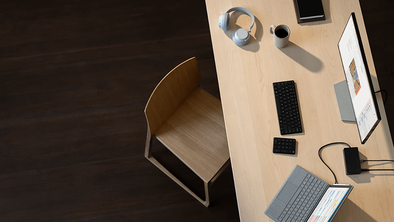 机の上の Surface Pro、Surface Headphones、マウス、キーボード