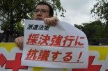 「いすゞ雇い止め裁判」の原告男性は、労働者派遣法の改悪が強行採決されると、すぐに抗議の声をあげた。＝19日正午ごろ、国会前　写真：筆者＝