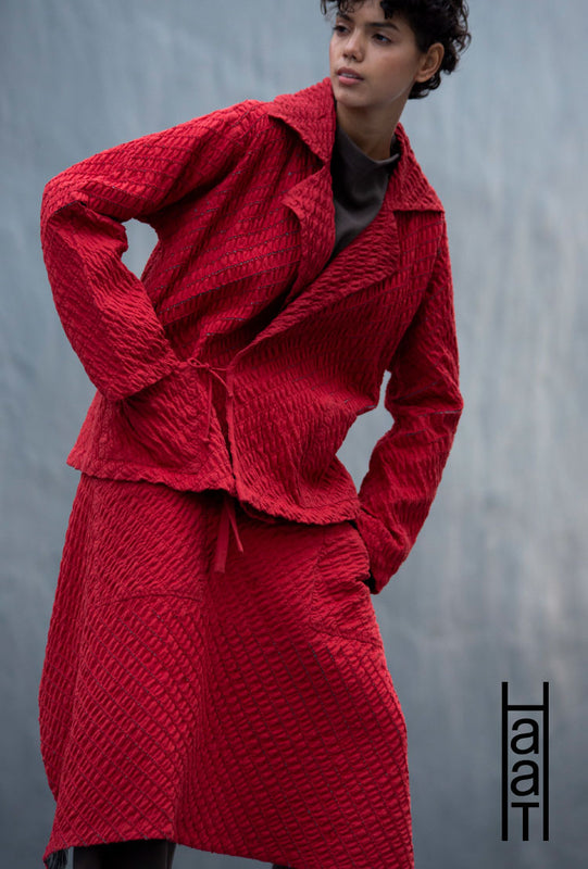 Main: Model wearing BIAS LINE jacket and skirt in red. Light grey background. Bottom right corner: Haat logo in black.