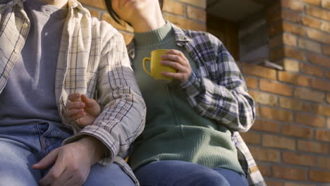 close-up view of caucasian couple talking while they drinking tea outside a country house