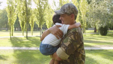 excited boy running to soldier dad's open arms