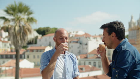 uomo omosessuale che beve champagne sullo sfondo del paesaggio urbano