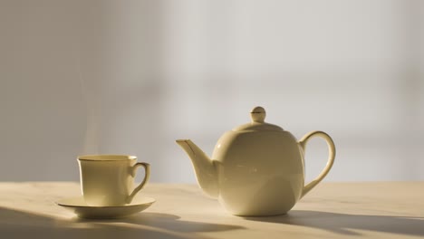 studio shot of making traditional british cup of tea using teapot 3