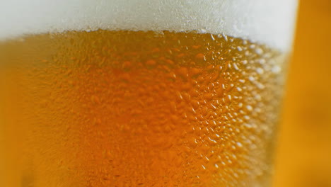 close-up slow motion: cold beer in a glass large drops and bubbles in the beer