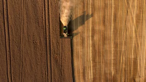 an aerial shot of a combine harvester working in a wheat field in the countryside in ukraine shot in 4k