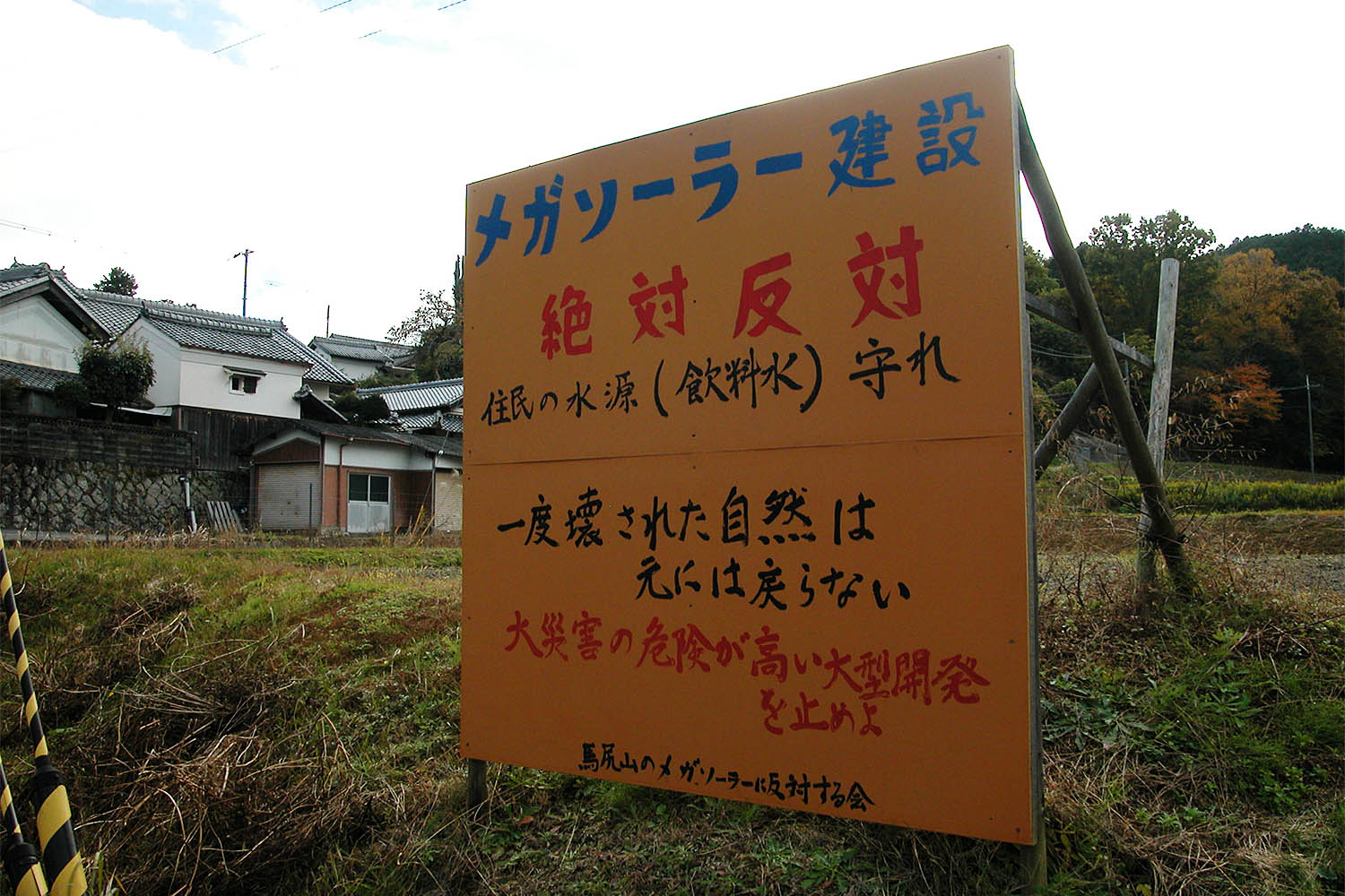 巨大太陽光発電計画に反対する看板。白壁の伝統的家屋が見える＝2022年11月14日、山添村